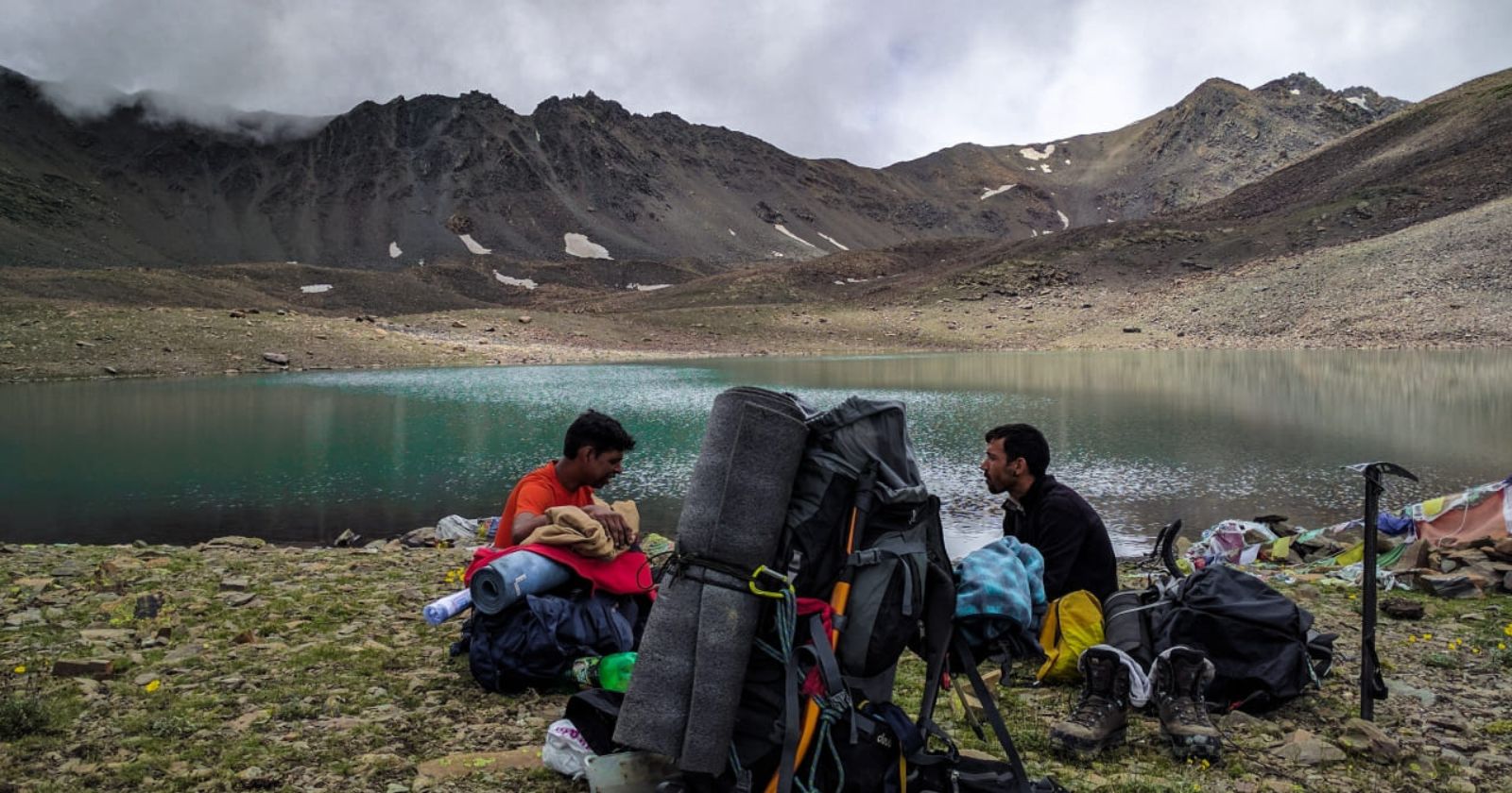 Hikers resting on the shore of Temso Lake