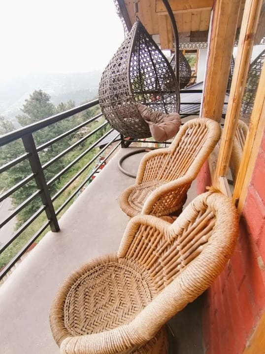 Swing and bamboo chairs in balcony of my hotel room in Narkanda