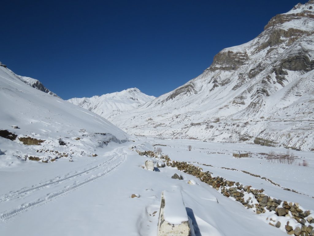 Trail left by a car on fresh snow covered road to Pin valley of Spiti.