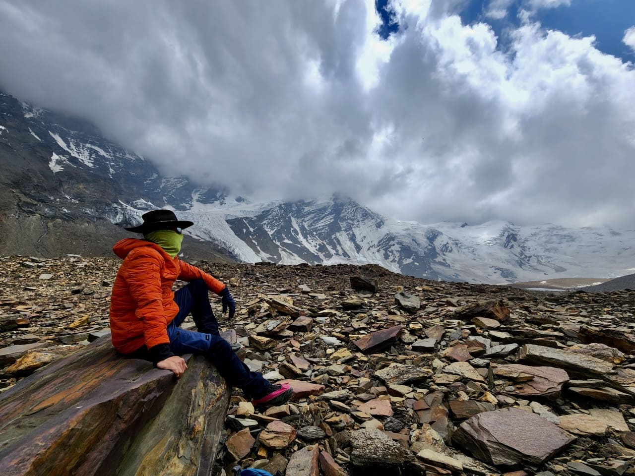 Hiker sitting on a boulder near Auden's Col base camp
